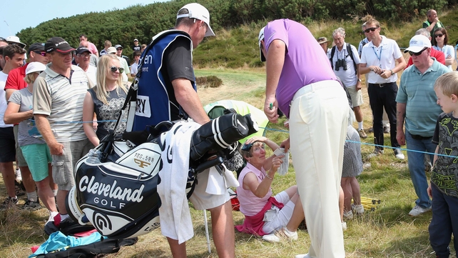 Shane Lowry gives a signed glove to a spectator he hit with his tee shot on the 8th hole