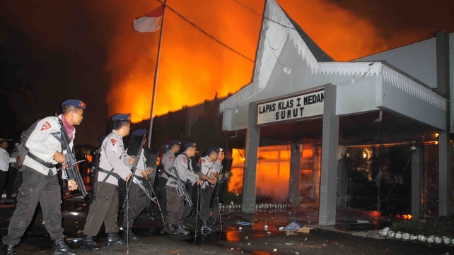 Armed Indonesian policemen secure the entrance of a compound at the prison in Medan Armed Indonesian policemen secure the entrance of a compound at the prison in Medan