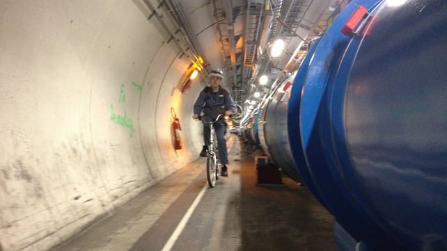A worker cycles through the Large Hadron Collider tunnel