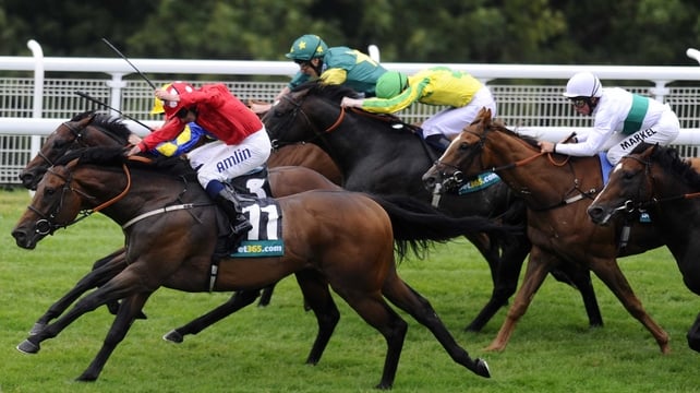 Ryan Moore riding Garswood (red) en route to victory at Glorious Goodwood