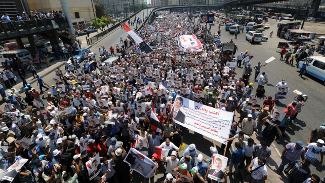 Pro-Mursi supporters carry posters bearing his portrait during a demonstration against the government in Cairo Pro-Mursi supporters carry posters bearing his portrait during a demonstration against the government in Cairo