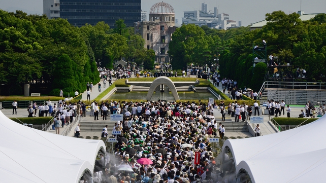 Crowds gather in Hiroshima Peace Park with the Atomic Bomb Dome visible in the background
