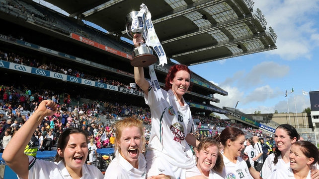 Clodagh Flanagan holds the junior camogie trophy aloft with her Kildare team-mates
