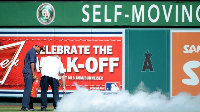 Ground staff attempt to remove bees that delayed the game at Angel Stadium Ground staff attempt to remove bees that delayed the game at Angel Stadium