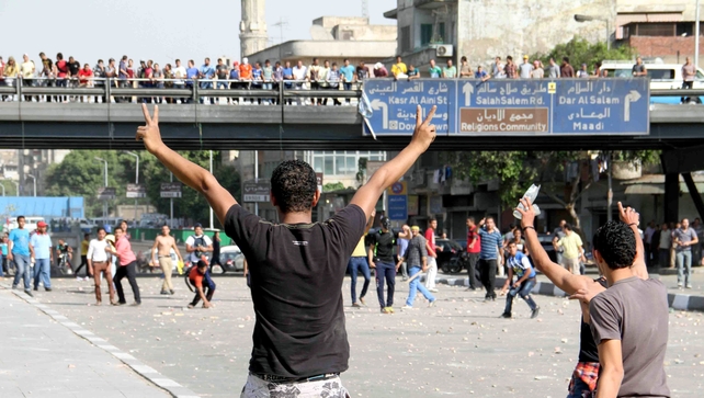 Supporters (background) and opponents of ousted Egyptian president clashed in Cairo yesterday Supporters (background) and opponents of ousted Egyptian president clashed in Cairo yesterday