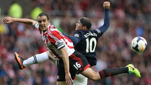 John O'Shea and Wayne Rooney vie for posession