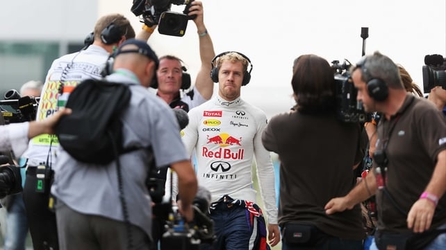 Sebastian Vettel is followed by camera crews on his way to his team garage during qualifying