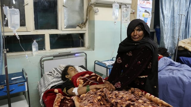 A woman holds the hands of a victim of the roadside bomb in hospital A woman holds the hands of a victim of the roadside bomb in hospital
