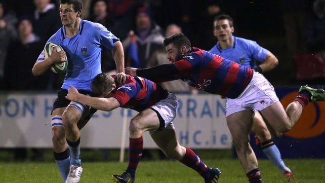 Clontarf's David Joyce and Michael McGrath tackle Eoin Joyce of UCD