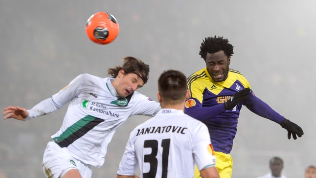 Swansea's Wilfried Bony heads clear from St Gallen's Daniele Russo and his teammate Dejan Janjatovic