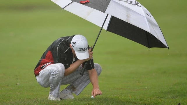 Michael Hoey attempts to remove his ball from the waterlogged turf in Durban