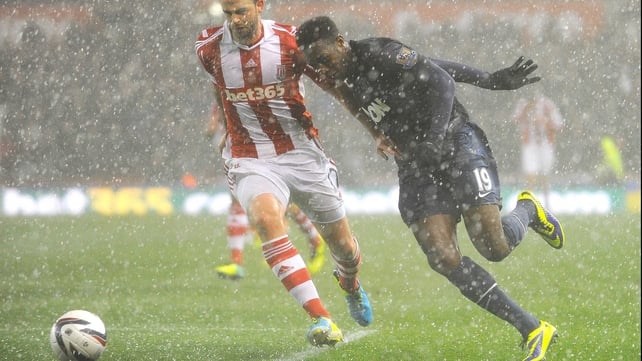 Marc Wilson and Danny Wellbeck challenge for the ball in heavy hail