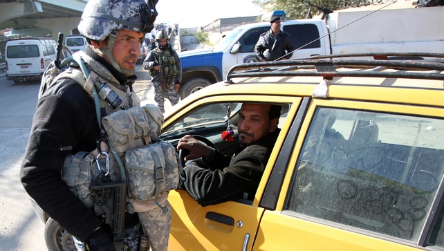 An Iraqi policeman checks a car at a checkpoint in Baghdad An Iraqi policeman checks a car at a checkpoint in Baghdad