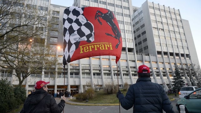 Fans hold a Ferrari flag in front of the Grenoble University Hospital Centre in support of Michael Schumacher
