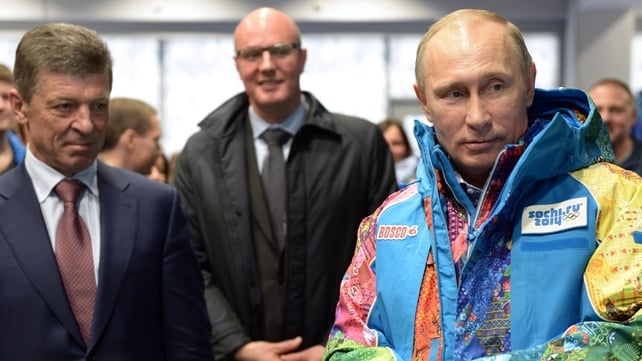 Russian President Vladimir Putin (R) tries an Olympic volunteers uniform, visiting an equipment centre in Sochi Russian President Vladimir Putin (R) tries an Olympic volunteers uniform, visiting an equipment centre in Sochi