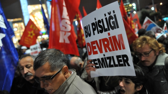 A Turkish protester holds up a placard reading 'Only revolution can clear this corruption' during a demonstration against the government A Turkish protester holds up a placard reading 'Only revolution can clear this corruption' during a demonstration against the government
