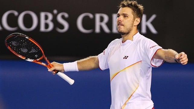 Stanislas Wawrinka raises his arms in triumph after Novak Djokovic volleys wide on match point