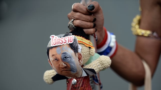 An protester holds a doll with a picture of former PM Thaksin Shinawatra and the word 'tyrant' An protester holds a doll with a picture of former PM Thaksin Shinawatra and the word 'tyrant'