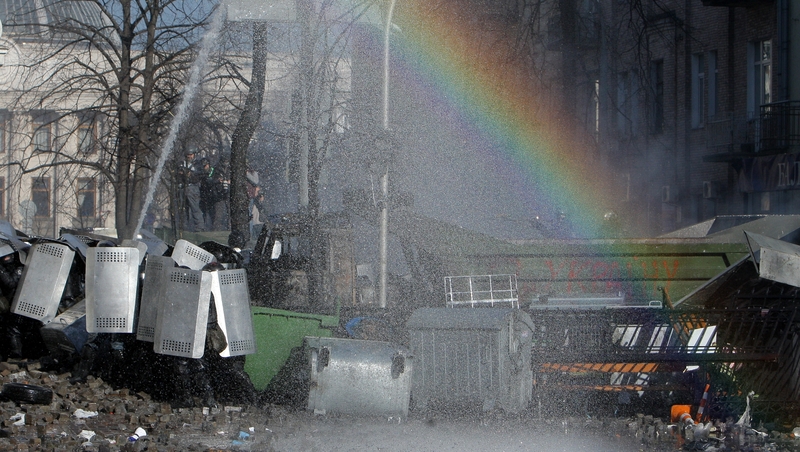 Protesters clash with riot police as a rainbow appears during continuing protests in downtown Kiev (EPA)