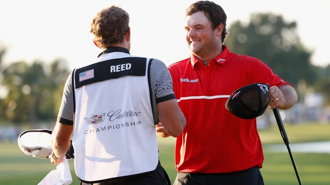 Patrick Reed celebrates with his caddie on the 18th green after his one-stroke victory
