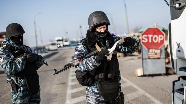 A pro-Russian serviceman checks a driver's documents at Chongar checkpoint blocking the entrance to Crimea A pro-Russian serviceman checks a driver's documents at Chongar checkpoint blocking the entrance to Crimea