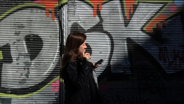 A Turkish woman uses her smartphone as she stands by a graffiti wall, on Istiklal street, in Istanbul A Turkish woman uses her smartphone as she stands by a graffiti wall, on Istiklal street, in Istanbul