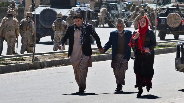 Afghan civilians flee after an Afghan election commission office is attacked by militants Afghan civilians flee after an Afghan election commission office is attacked by militants