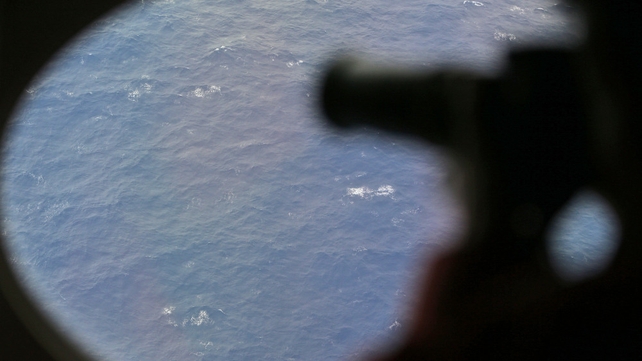 An observer on a Japan Coast Guard Gulfstream aircraft takes photos while searching Flight MH370 An observer on a Japan Coast Guard Gulfstream aircraft takes photos while searching Flight MH370