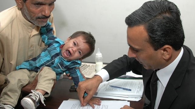 A Pakistani lawyer takes the thumb impression from the nine-month-old baby A Pakistani lawyer takes the thumb impression from the nine-month-old baby