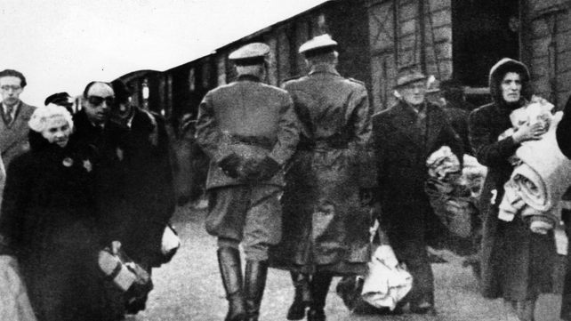 Nazi officers supervise Jews leaving railway trucks during the deportation to the camps Nazi officers supervise Jews leaving railway trucks during the deportation to the camps
