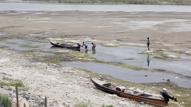 Iraqi men move a boat that was stuck on the banks of the Euphrates in Twairij due to a decline in the water level Iraqi men move a boat that was stuck on the banks of the Euphrates in Twairij due to a decline in the water level