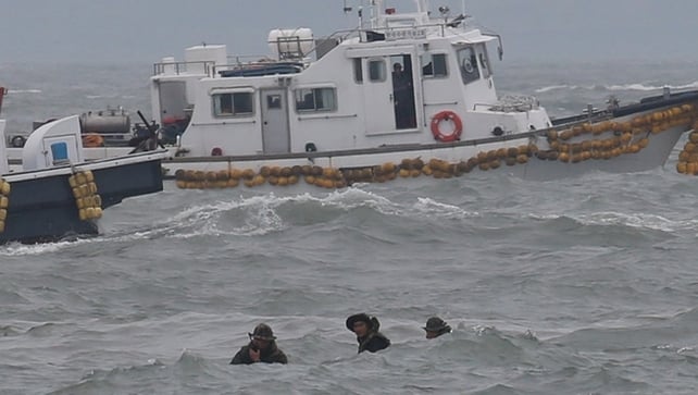 Divers fight against high waves as they struggle to search for hundreds of missing passengers Divers fight against high waves as they struggle to search for hundreds of missing passengers