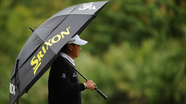 Leader KJ Choi shields himself from the rain in South Carolina