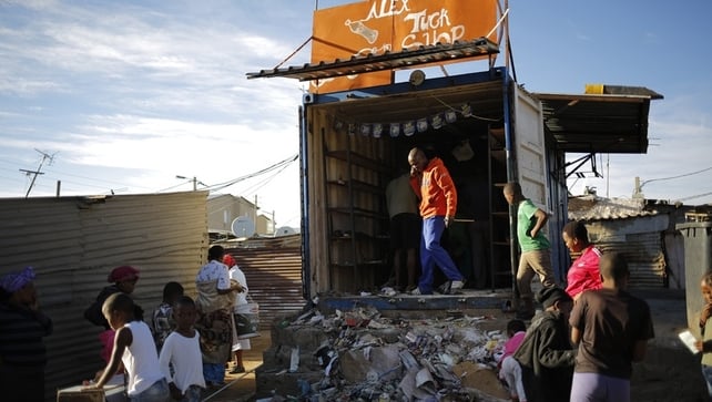 A shop owner cleans up after overnight violence in the Alexandra township A shop owner cleans up after overnight violence in the Alexandra township
