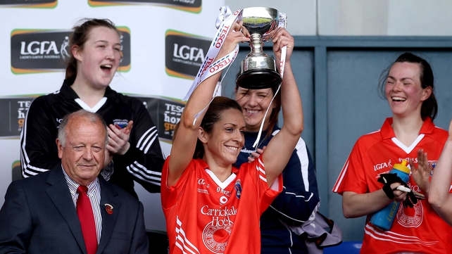 Caitlin Malone lifts the trophy after the game