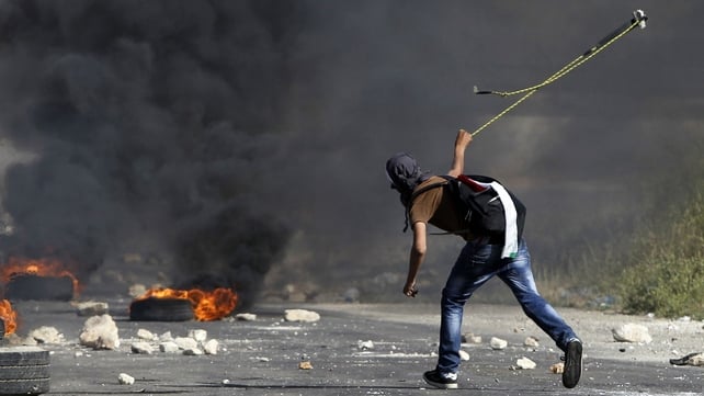 A masked Palestinian demonstrator uses a slingshot during clashes with members of the Israeli security forces outside the Israeli-run Ofer prison in the West Bank village of Betunia, on 16 May, the day after two Palestinian youths were shot dead by Israel A masked Palestinian demonstrator uses a slingshot during clashes with members of the Israeli security forces outside the Israeli-run Ofer prison in the West Bank village of Betunia, on 16 May, the day after two Palestinian youths were shot dead by Israel