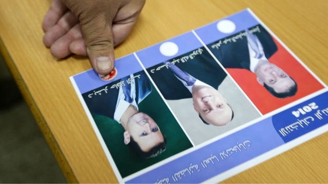 A Syrian man presses his thumb, a drop of blood on it, onto a ballot paper A Syrian man presses his thumb, a drop of blood on it, onto a ballot paper