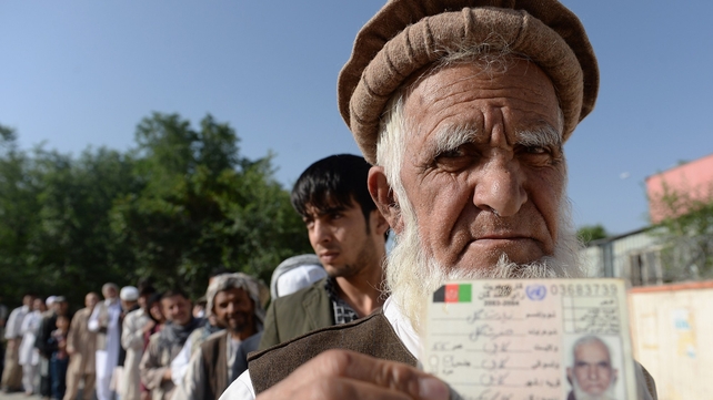 An Afghan resident wanting to vote poses for a photograph with his identity card as he waits for voting to start An Afghan resident wanting to vote poses for a photograph with his identity card as he waits for voting to start