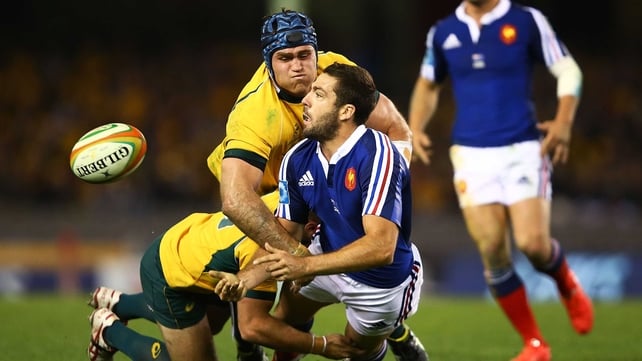 Remi Tales of France offloads under pressure from two Australian tacklers