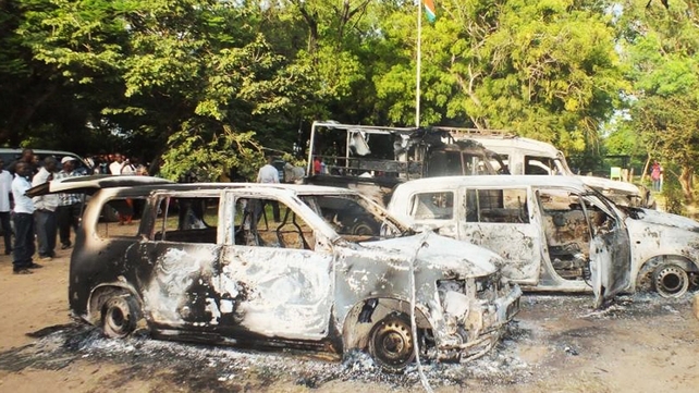 People gather next to charred vehicles outside a police station in Mpeketoni after the attacks People gather next to charred vehicles outside a police station in Mpeketoni after the attacks