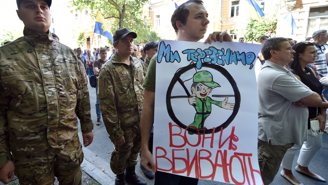 A man holds a sign reading 'We chat - they kill!' at a rally by Maidan activists at Independence Square in Kiev A man holds a sign reading 'We chat - they kill!' at a rally by Maidan activists at Independence Square in Kiev