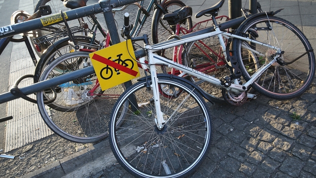 Bicycles lie chained to a barrier next to a sign explicity forbidding their presence at Alexanderplatz Bicycles lie chained to a barrier next to a sign explicity forbidding their presence at Alexanderplatz