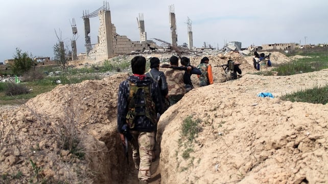 Rebel fighters carry their weapons as they walk along a trench in the northeastern city of Deir Ezzor Rebel fighters carry their weapons as they walk along a trench in the northeastern city of Deir Ezzor