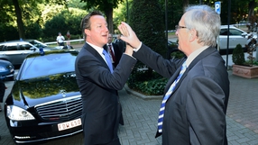 British Prime Minister David Cameron high fives European Commission President Jean-Claude Juncker in Brussels