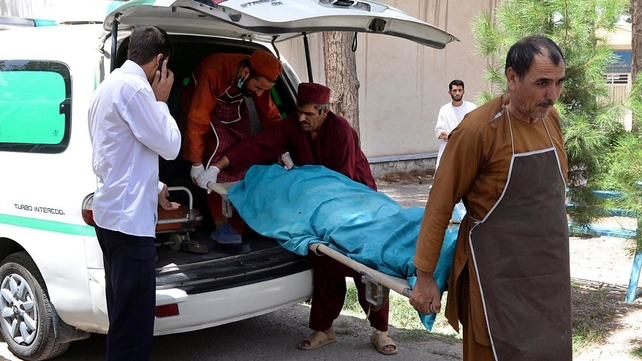 Afghan medical workers carry one of the bodies into the morgue of Herat Hospital Afghan medical workers carry one of the bodies into the morgue of Herat Hospital