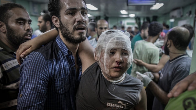 A father brings his son for treatment following the attack on the school