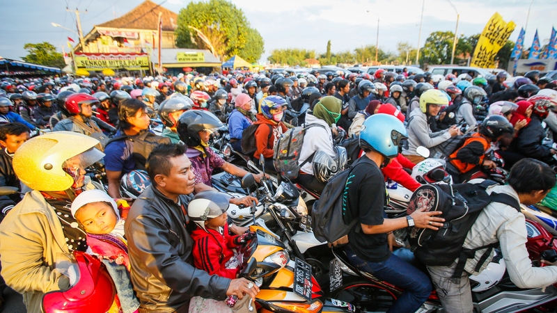 Indonesians on motorbikes queue to board a passenger ship in Bali ahead of the Muslim Eid al-Fitr festival