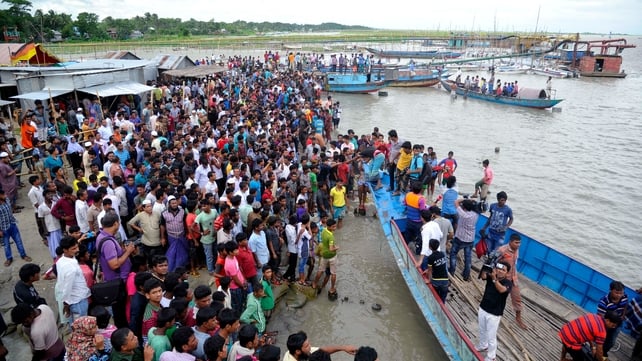 Local people and relatives gather at a beach after a ferry carrying capsized in the Padma River Local people and relatives gather at a beach after a ferry carrying capsized in the Padma River