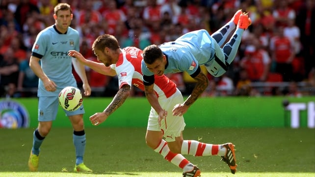 Arsenal's Mathieu Debuchy and Aleksandar Kolarov of City collide