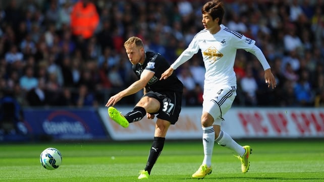 Burnley forward Scott Arfield gets in a shot at goal despite the attentions of Ki Sung-Yueng